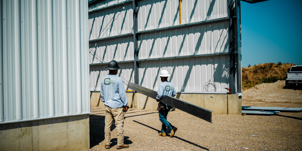 workers on site at under construction steel building